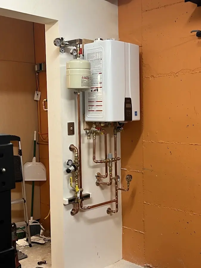 Plumbing technician inspecting water heater connections in Westphalia